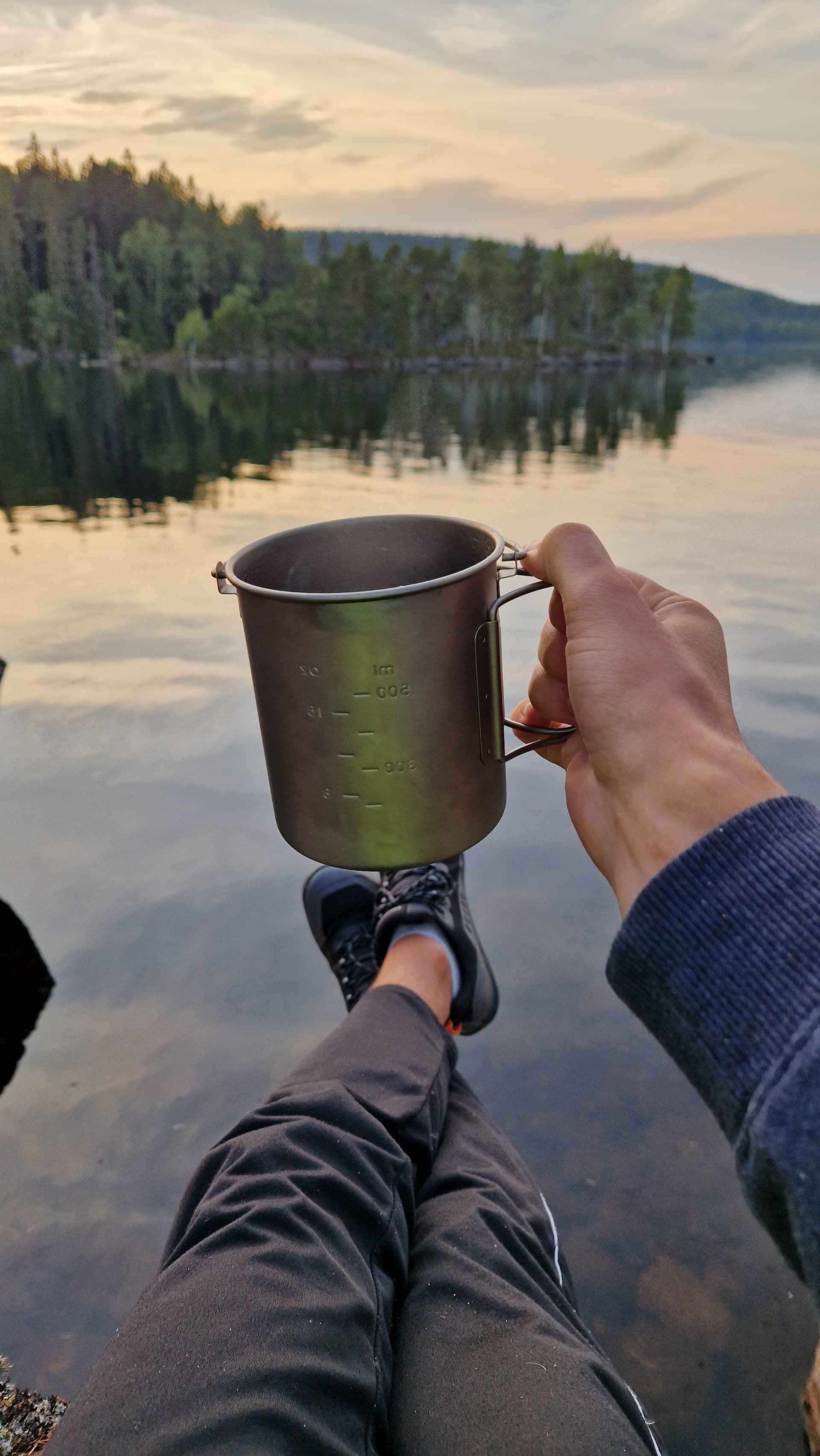 Cup being held with a lake in the background. Cup being held with a lake in the background.